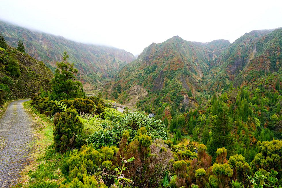 Vale das Lombadas - kleine Strasse aus Pflastersteinen führt den steilen Berghang hinunter in die Lombadas Schlucht - Sao Miguel, Azoren